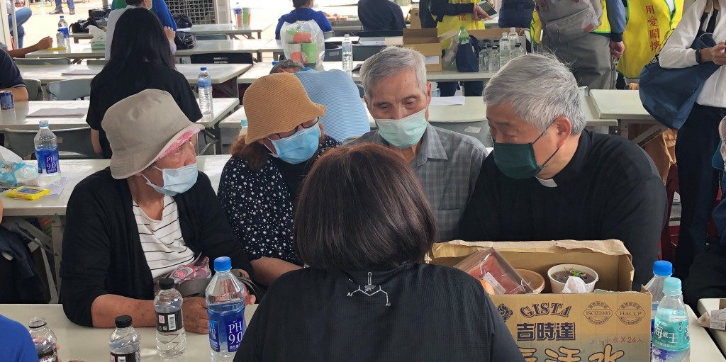 林維道牧師在會場陪伴兒孫罹難的張武忠牧師夫婦及親人(李容珍攝影)