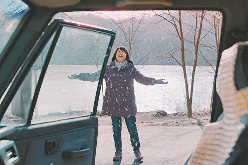 獨自從新加坡來韓國旅遊的林美華，遇到下雪興奮地衝出車外。（劇照提供：采昌國際）
