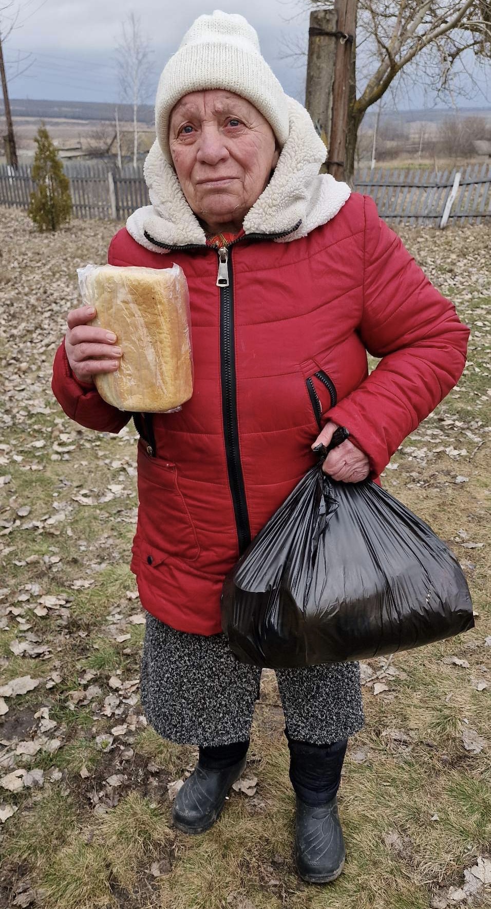 拿著一條麵包的老婦人