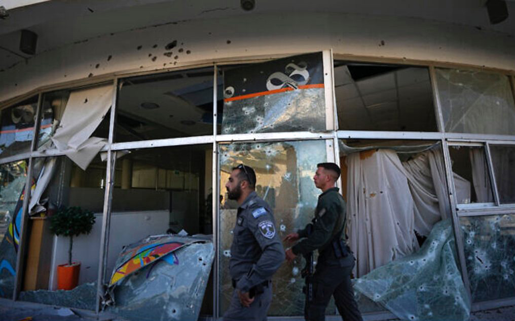2023年4月6日（週四），以色列安全部隊行走在一間銀行旁邊，該銀行被從黎巴嫩發射的火箭彈毀損，該火箭彈落在靠近黎巴嫩邊境以色列北部城市什洛米，日前此銀行因逾越節而未營業。（照片來源：AP Photo/Ariel Schalit）