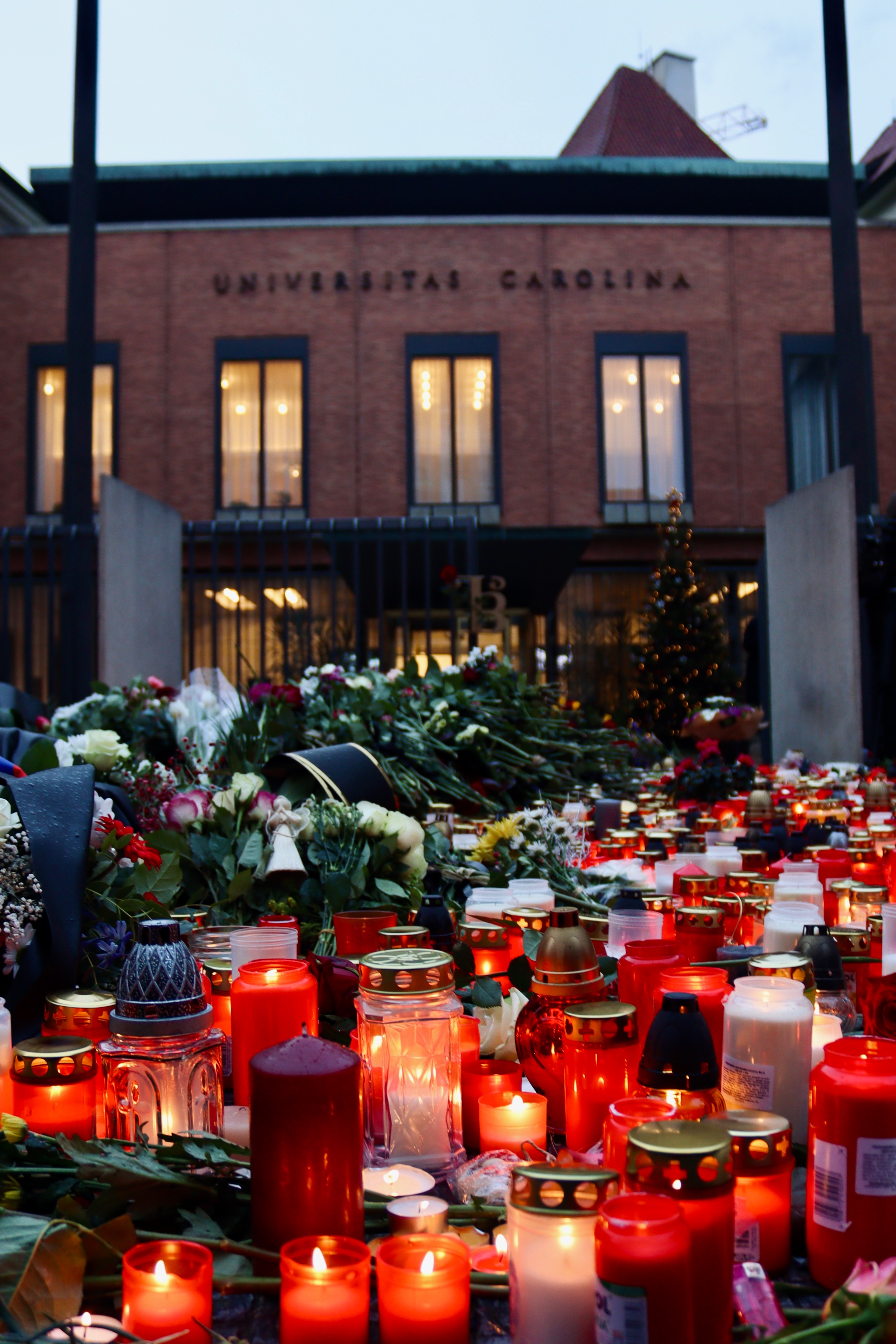 校門口放滿了哀悼者前來致意的蠟燭與花朵。（圖／翻攝自X @CharlesUniPRG）