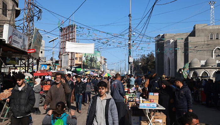  2024年3月10日，巴勒斯坦人們走過加薩走廊南部拉法一條街道上擺放的攤位，穆斯林正在為神聖的齋戒月做準備。（照片來源：Mohammed Abed/AFP）